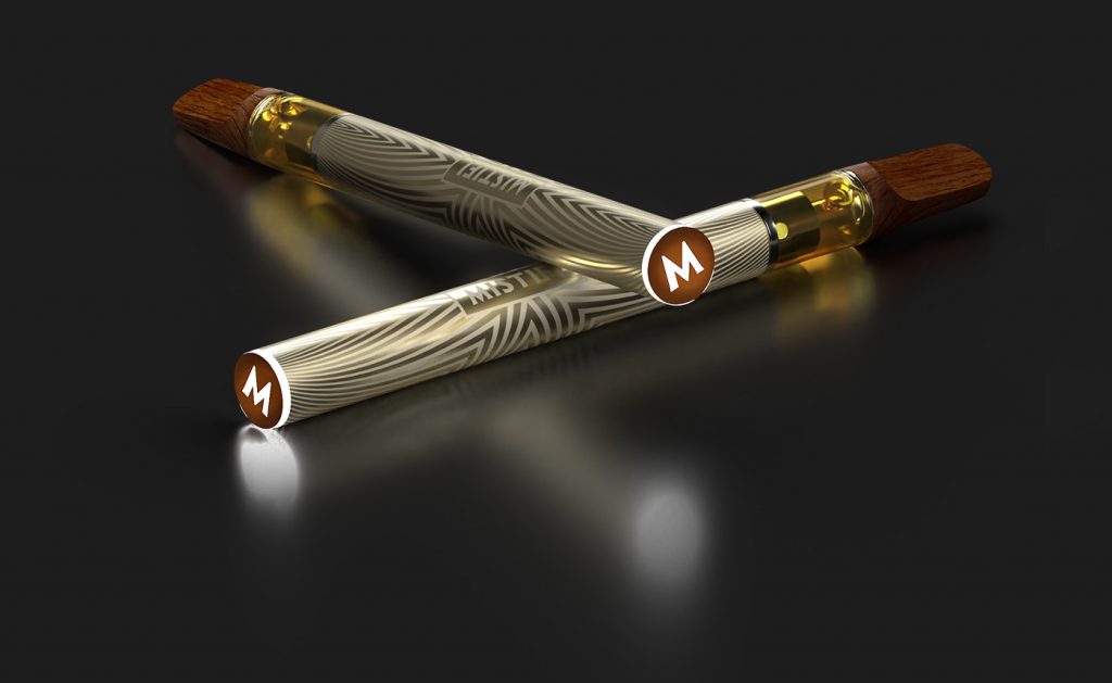 Two MISTIFI Premium Cannabis Vape Pens laying crossed on dark background glowing M indicator